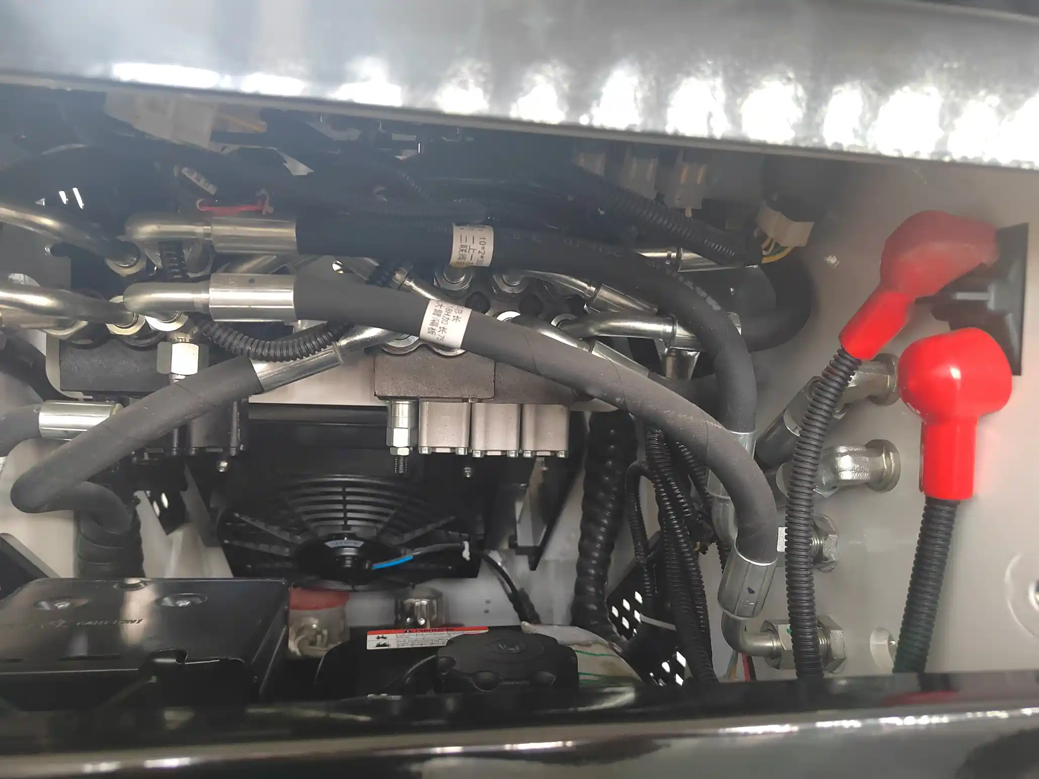 Loader diagram highlighting fluids, hoses, attachment lock, undercarriage and cooling area