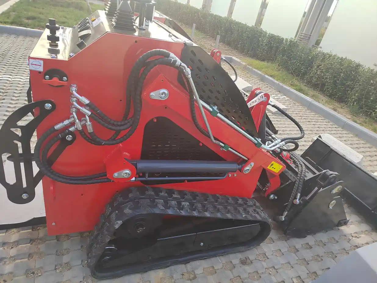 Red tracked mini skid loader viewed from the side