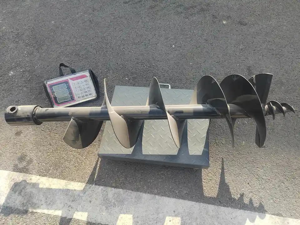 Auger drill attachment for a tracked skid steer loader