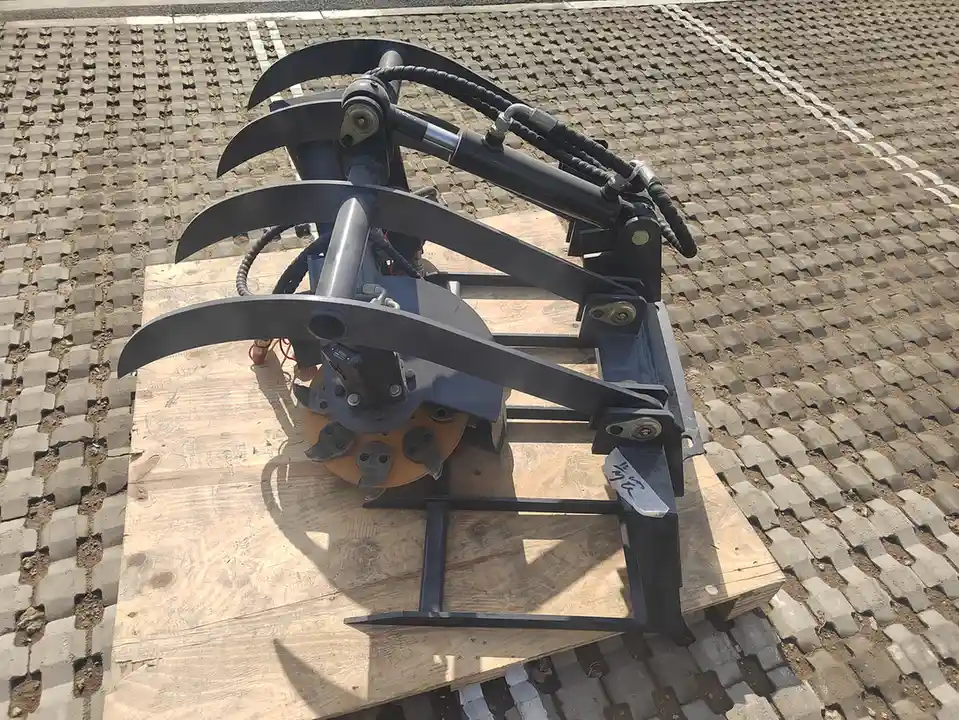 Hydraulic grapple rake attachment for a tracked skid steer