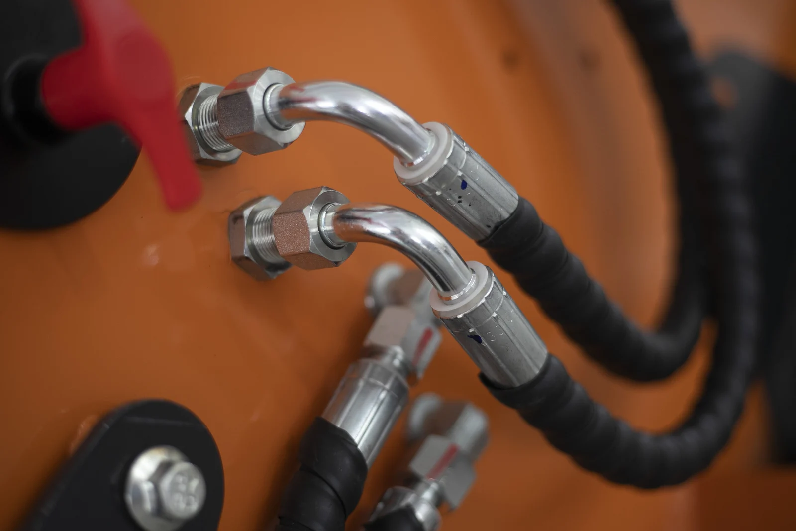 Hydraulic hose fittings on a skid steer loader