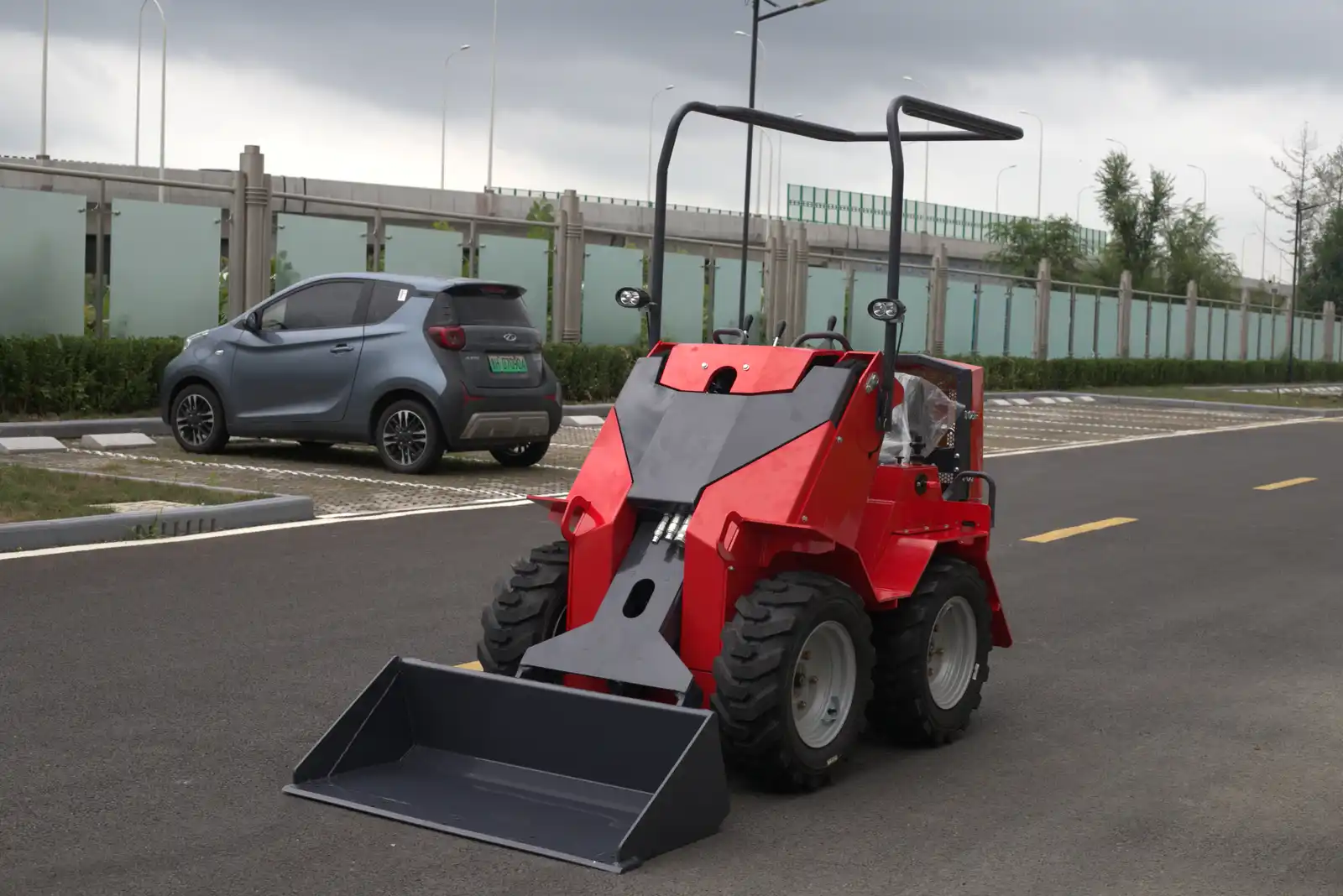 Red wheeled skid steer loader with front bucket
