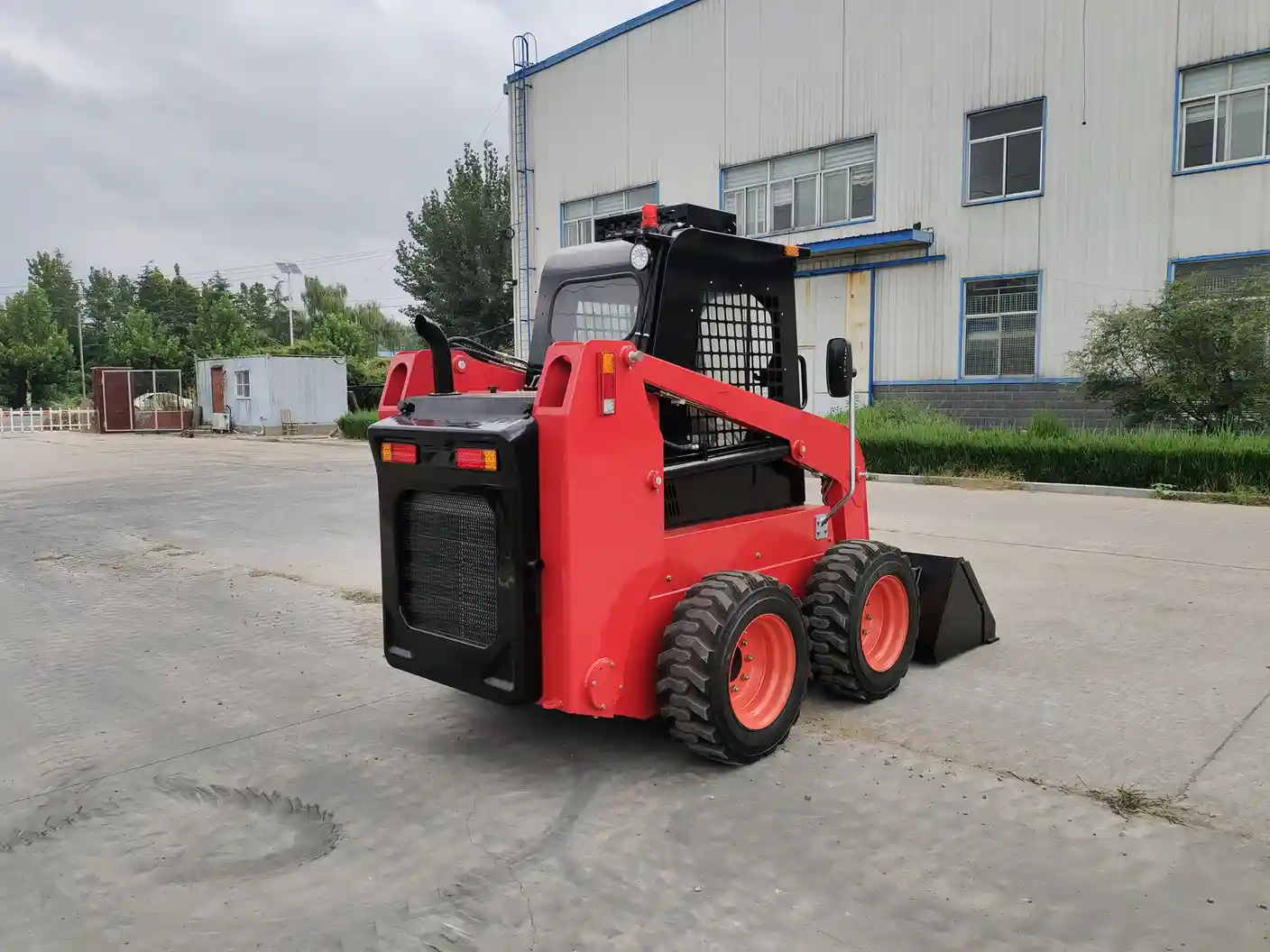 Red wheeled skid steer undergoing an operator function check